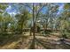 A home with a stone chimney, surrounded by trees and yard at 7740 Sw 70Th Ave, Ocala, FL 34476