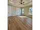 Serene bedroom showcasing wood floors, tray ceiling with fan, and windows providing natural light at 8481 Sw 137 Ct, Dunnellon, FL 34432