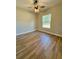 Bedroom with hardwood floors, neutral paint, a ceiling fan, and a window overlooking the yard at 8481 Sw 137 Ct, Dunnellon, FL 34432