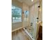 Close-up of a shower with a glass door, pebble flooring, and white tiled walls at 8481 Sw 137 Ct, Dunnellon, FL 34432