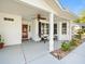 Inviting covered front porch featuring a ceiling fan, seating, and views of the landscaped front yard at 8510 Sw 108Th Place Rd, Ocala, FL 34481