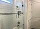 Bathroom shower featuring white tile, a glass door, and a shower niche at 8630 Sw 61St Loop, Ocala, FL 34481