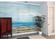 Cozy living room featuring a mural of a beach, a green plant, and red cabinet at 8630 Sw 61St Loop, Ocala, FL 34481