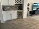 Bar area featuring white cabinets, wine cooler, and dark backsplash at 8630 Sw 61St Loop, Ocala, FL 34481