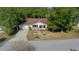 Aerial view of a charming single-story home featuring mature trees, a long drive and a two-car garage at 8639 Sw 116Th Lane Rd, Ocala, FL 34481