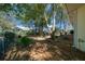 Spacious backyard with mature trees, landscaping, and a charming patio area at 8639 Sw 116Th Lane Rd, Ocala, FL 34481