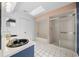 A bright bathroom featuring double sinks, white tile floors, and a tub-shower combination at 8639 Sw 116Th Lane Rd, Ocala, FL 34481