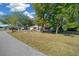 Street view of a well-maintained single-story home with green grass, mature trees, and a landscaped front yard at 8639 Sw 116Th Lane Rd, Ocala, FL 34481