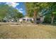 View of a single-Gathering home with a landscaped front yard, mature trees, and a concrete driveway at 8639 Sw 116Th Lane Rd, Ocala, FL 34481