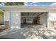 Spacious garage featuring a sliding screen door, storage shelves, and utility connections at 8639 Sw 116Th Lane Rd, Ocala, FL 34481