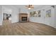 Cozy living room featuring a brick fireplace, tile flooring, and natural light at 8639 Sw 116Th Lane Rd, Ocala, FL 34481