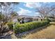 Back exterior view showcasing covered porch and sunroom, lined with privacy bushes at 8707 Sw 95Th Ln # G, Ocala, FL 34481