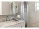 Bathroom featuring a marble vanity with modern fixtures, a stylish mirror, and a shower with marble-look tiles at 8707 Sw 95Th Ln # G, Ocala, FL 34481