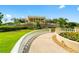 Community clubhouse entrance with manicured lawns, stone walls and decorative flowers at 8707 Sw 95Th Ln # G, Ocala, FL 34481