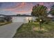 Charming single-story home at sunset with lush front lawn and mature palm trees at 8707 Sw 95Th Ln # G, Ocala, FL 34481