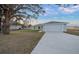 Newly built home with gray siding and a large oak tree at 9731 Bahia Rd, Ocala, FL 34472