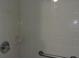 Close-up of the tiled shower stall with handrails and a soap dish at 10015 Sw 90Th Ct, Ocala, FL 34481