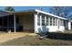 Angle view of this charming home highlighting the carport and window-lined side of the house at 10015 Sw 90Th Ct, Ocala, FL 34481