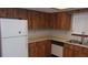 Efficient kitchen featuring wood cabinetry and a white refrigerator at 10015 Sw 90Th Ct, Ocala, FL 34481