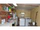 This laundry room includes a washer, dryer, water heater, and shelf storage at 10015 Sw 90Th Ct, Ocala, FL 34481