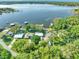 Stunning aerial view of a lakeside property showcasing lush greenery and serene water views at 10900 Se Timucuan Rd, Summerfield, FL 34491