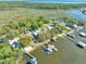 Aerial view of waterfront homes with docks, boat houses, pools, and lush green landscaping at 10900 Se Timucuan Rd, Summerfield, FL 34491
