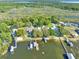 Aerial view of waterfront homes with docks and boat houses surrounded by lush trees at 10900 Se Timucuan Rd, Summerfield, FL 34491