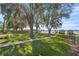 Beautifully landscaped yard with mature trees and lake access, creating a serene outdoor retreat at 10900 Se Timucuan Rd, Summerfield, FL 34491