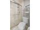 Bright bathroom featuring tiled shower with glass door, and a convenient toilet with shelving at 10900 Se Timucuan Rd, Summerfield, FL 34491