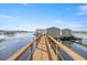 Picturesque view of a private dock on the lake, complete with boat house and charming details at 10900 Se Timucuan Rd, Summerfield, FL 34491