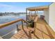 Lake dock view with covered boat lift, swim ladder, and seating area for lakeside relaxation at 10900 Se Timucuan Rd, Summerfield, FL 34491
