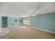 Large living room featuring neutral carpet, ceiling fans, and plenty of natural light at 10900 Se Timucuan Rd, Summerfield, FL 34491
