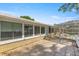 Backyard patio area with a walkway to the pool and lanai, surrounded by lush greenery at 10900 Se Timucuan Rd, Summerfield, FL 34491