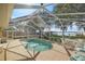 Screened pool with brick patio overlooking a serene lake with a dock, ideal for relaxation and entertaining at 10900 Se Timucuan Rd, Summerfield, FL 34491