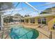 Backyard view of pool and patio. Enclosed screened pool deck with chairs and tables for entertaining at 10900 Se Timucuan Rd, Summerfield, FL 34491