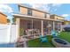 Inviting screened patio and backyard featuring cozy seating, a fire pit, and synthetic grass area at 12312 Ne 48Th Loop, Oxford, FL 34484
