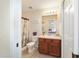 Cozy bathroom features a shower with curtains, and a wood vanity with sink and nice lighting at 12312 Ne 48Th Loop, Oxford, FL 34484