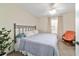A neutral-toned bedroom with a woven chair placed near the window at 12312 Ne 48Th Loop, Oxford, FL 34484