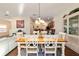 Bright dining area features a wood table, white chairs, and seamless transition to living spaces, creating a welcoming atmosphere at 12312 Ne 48Th Loop, Oxford, FL 34484