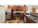 Well-equipped kitchen with stainless steel appliances, wood cabinetry, and granite countertops at 12312 Ne 48Th Loop, Oxford, FL 34484