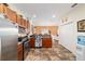 Open kitchen with stainless steel appliances, wood cabinets, and seamless access to the living area, perfect for entertaining at 12312 Ne 48Th Loop, Oxford, FL 34484