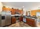 Well-lit kitchen features stainless steel appliances, wooden cabinetry, and a convenient breakfast bar at 12312 Ne 48Th Loop, Oxford, FL 34484