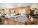 Bright living room with hardwood floors, large sectional, and dining area in the background at 12312 Ne 48Th Loop, Oxford, FL 34484