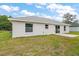 The backyard features a well-maintained lawn, a concrete patio, and sliding glass doors that leads indoors at 13743 Sw 113 Ln, Dunnellon, FL 34432