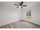 Bright bedroom features a modern ceiling fan, a window with natural light and wood-look laminate flooring at 13743 Sw 113 Ln, Dunnellon, FL 34432