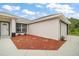 Well-manicured front lawn, red mulch flower bed, and a welcoming entrance create a warm curb appeal at 13743 Sw 113 Ln, Dunnellon, FL 34432