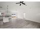 Bright, open-concept living room featuring modern gray flooring, a ceiling fan, and updated white cabinets at 13743 Sw 113 Ln, Dunnellon, FL 34432