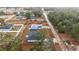 An aerial view of a quaint home with a gray roof surrounded by lush trees and a large, enclosed yard at 13757 Sw 113 Ln, Dunnellon, FL 34432