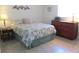 Cozy bedroom featuring tile flooring, a floral bedspread, and a classic wooden dresser at 13779 Sw 115Th Cir, Dunnellon, FL 34432