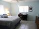 Cozy bedroom featuring a comfortable bed, desk area, a ceiling fan, and natural light from the window at 13779 Sw 115Th Cir, Dunnellon, FL 34432